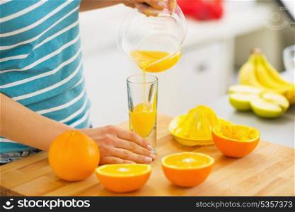 Closeup on woman pouring juice into glass