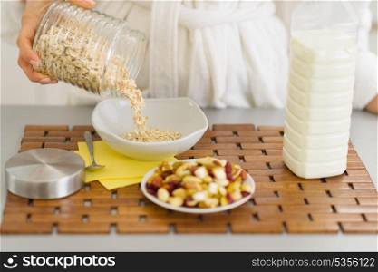 Closeup on woman putting oatmeal into plate