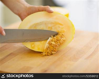 Closeup on woman removing seeds from melon slice
