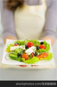 Closeup on woman showing fresh salad
