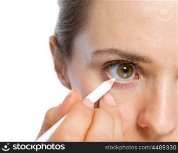 Closeup on woman using white eye liner
