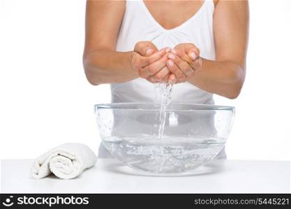 Closeup on woman washing hands in glass bowl with water