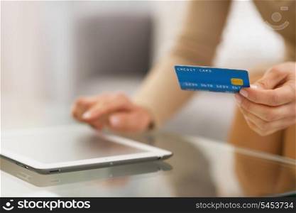 Closeup on woman with credit card using tablet pc