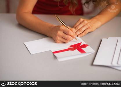Closeup on woman writing on christmas letter in kitchen