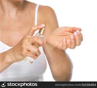 Closeup on young woman applying perfume on hand