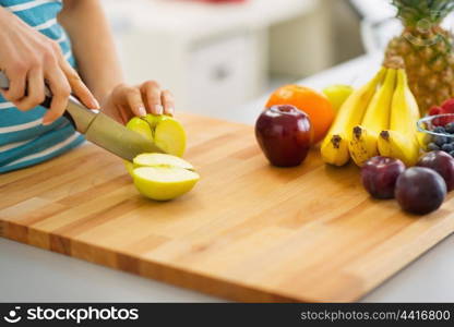 Closeup on young woman cutting apple