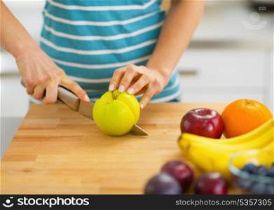 Closeup on young woman cutting apple