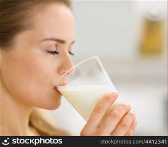 Closeup on young woman drinking milk