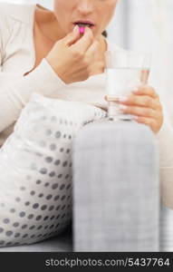 Closeup on young woman eating pill