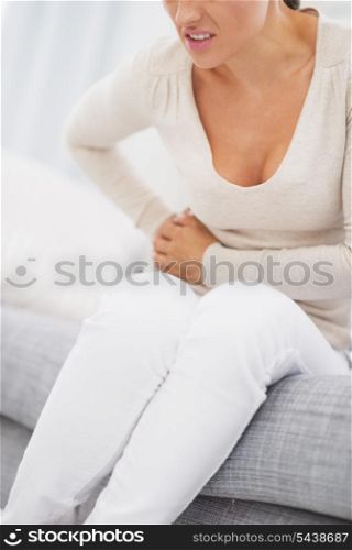 Closeup on young woman having stomach pain