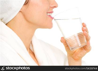 Closeup on young woman in bathrobe drinking water