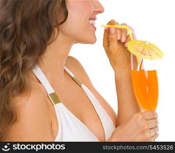 Closeup on young woman in swimsuit drinking cocktail