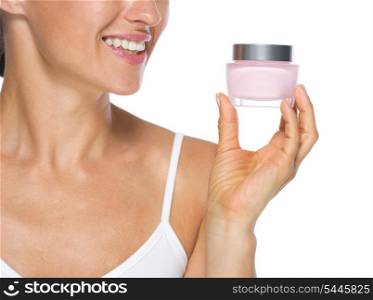 Closeup on young woman looking on cream bottle