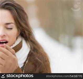Closeup on young woman warming hands in winter park