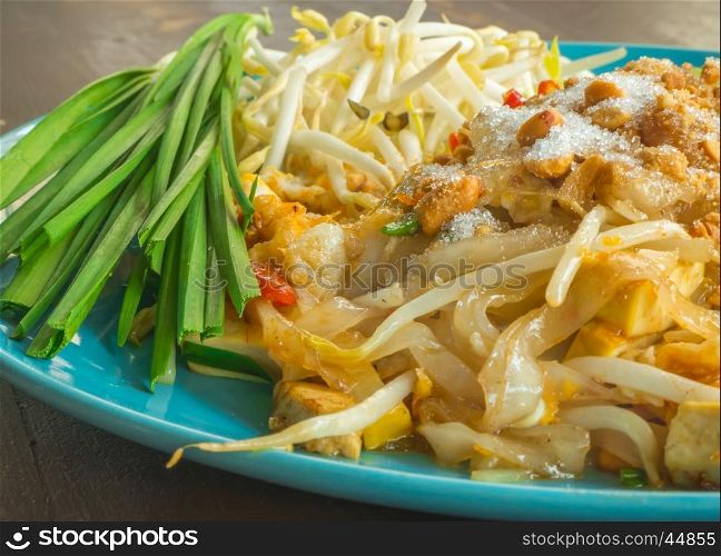 Closeup Pad Thai with blue dish on wooden table, Thai food