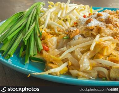 Closeup Pad Thai with blue dish on wooden table, Thai food
