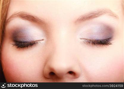 Closeup part of face beautiful female eyes with blue violet make-up visage, applying makeup on eyes