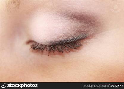 Closeup part of face female eye, woman applying makeup on eyes with brush