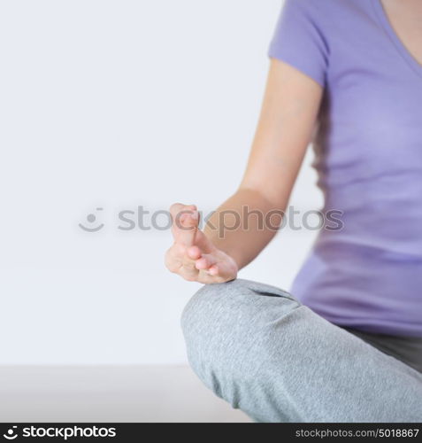 Closeup part of female body meditating. Focus on fingers