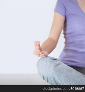 Closeup part of female body meditating. Focus on fingers