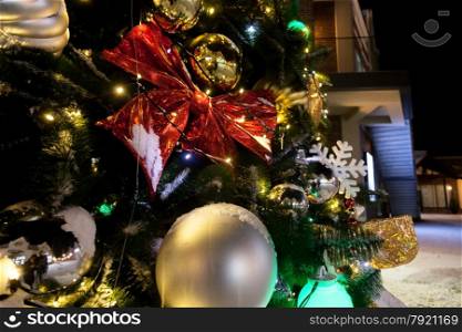 Closeup photo at night of christmas tree decorated with balls
