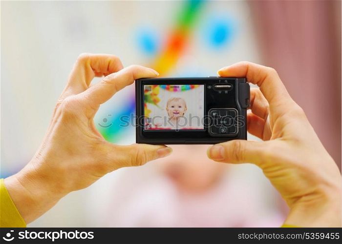 Closeup photo camera on mothers hands making birthday photos