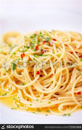 Closeup photo of a pasta flavored with basil, chilli and bell pepper, tasty traditional Italian dish, beautiful and delicious restaurant meal
