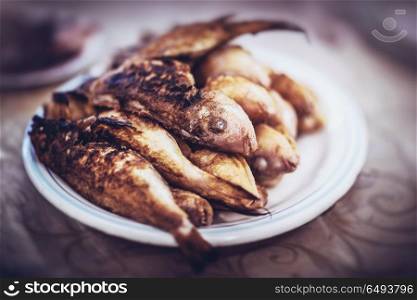 Closeup photo of a plate with tasty grilled fish, delicious grilled on barbeque fishes, healthy diet food. Tasty grilled fishes