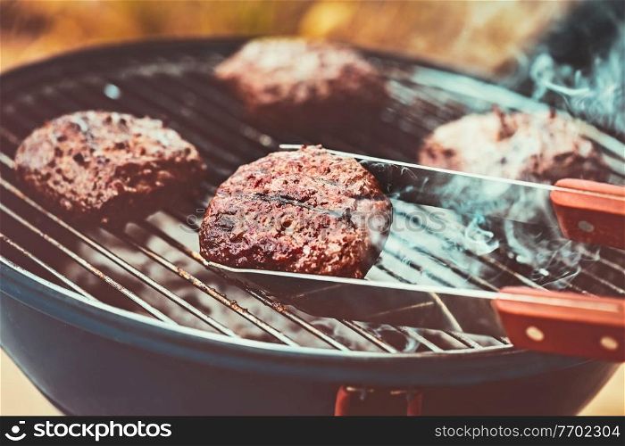 Closeup photo of a tasty vegetarian burger on the grill outdoors, bbq picnic, healthy delicious food, happy summer weekend