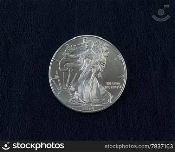 Closeup photo of an uncirculated American Silver Eagle Coin Dollar on dark blue vinyl holder