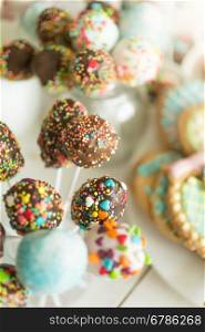 Closeup photo of beautiful colorful cake pops on white wooden background
