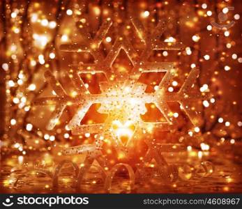 Closeup photo of beautiful golden Christmas time decoration, shiny snowflake with ball shape burning candle, luxury festive ornament