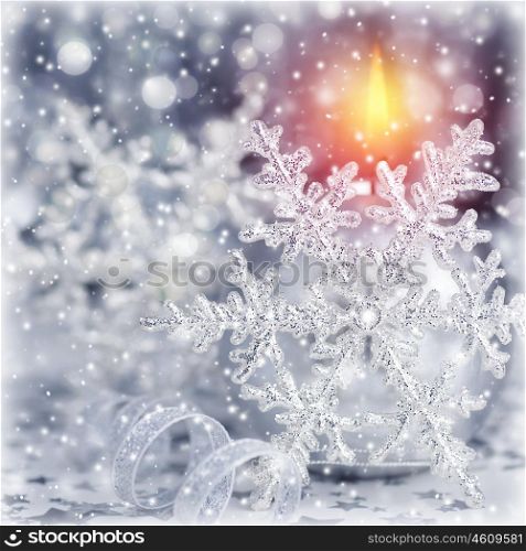 Closeup photo of beautiful silver Christmas time decoration, shiny snowflake with ball shape burning candle, luxury festive ornament