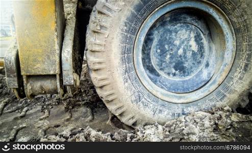 Closeup photo of big dirt wheel of heavy truck on building site