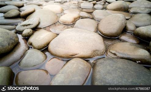 Closeup photo of big round stones in river