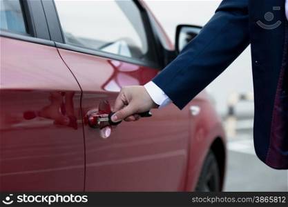 Closeup photo of businessman hand opening car door