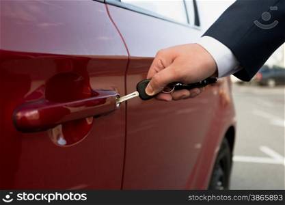 Closeup photo of businessman opening parked car with key
