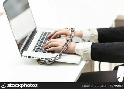 Closeup photo of businesswoman locked to laptop by chain
