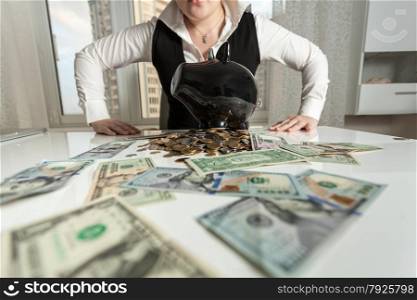 Closeup photo of businesswoman sitting behind table with piggy bank