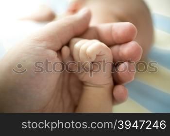 Closeup photo of caring father folding little son hand. Concept of care and protection