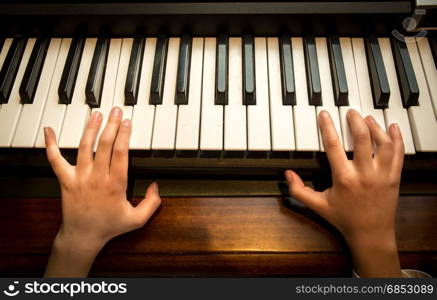 Closeup photo of child&rsquo;s hands playing on the piano