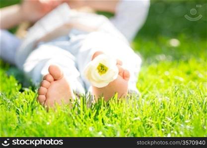 Closeup photo of children`s feet with flower in spring park