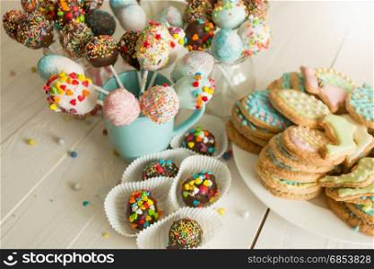 Closeup photo of colorful cake pops and cookies with icing