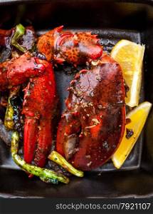 Closeup photo of cooked lobster claw with lemon and vegetables