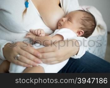 Closeup photo of cute baby sleeping on mothers hands after eating milk