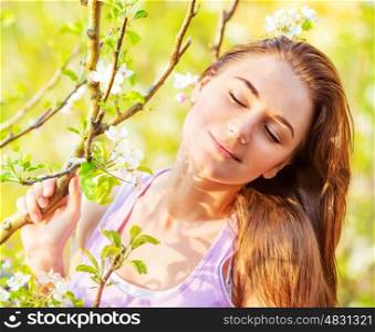 Closeup photo of cute girl with closed eyes outdoors, sunny day, blooming tree, spring garden, carefree concept
