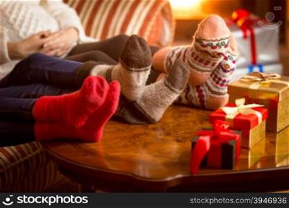 Closeup photo of family&rsquo;s legs in woolen socks next to fireplace at Christmas