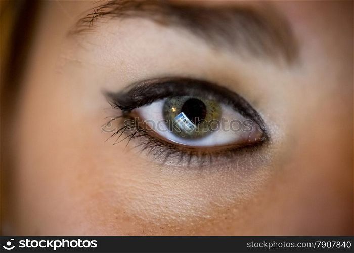 Closeup photo of female eye with computer screen reflecting in it