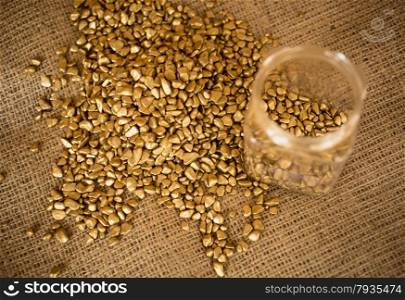 Closeup photo of golden nuggets and empty bullion lying on burlap