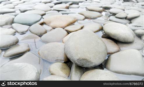 Closeup photo of gray pebbles lying in river